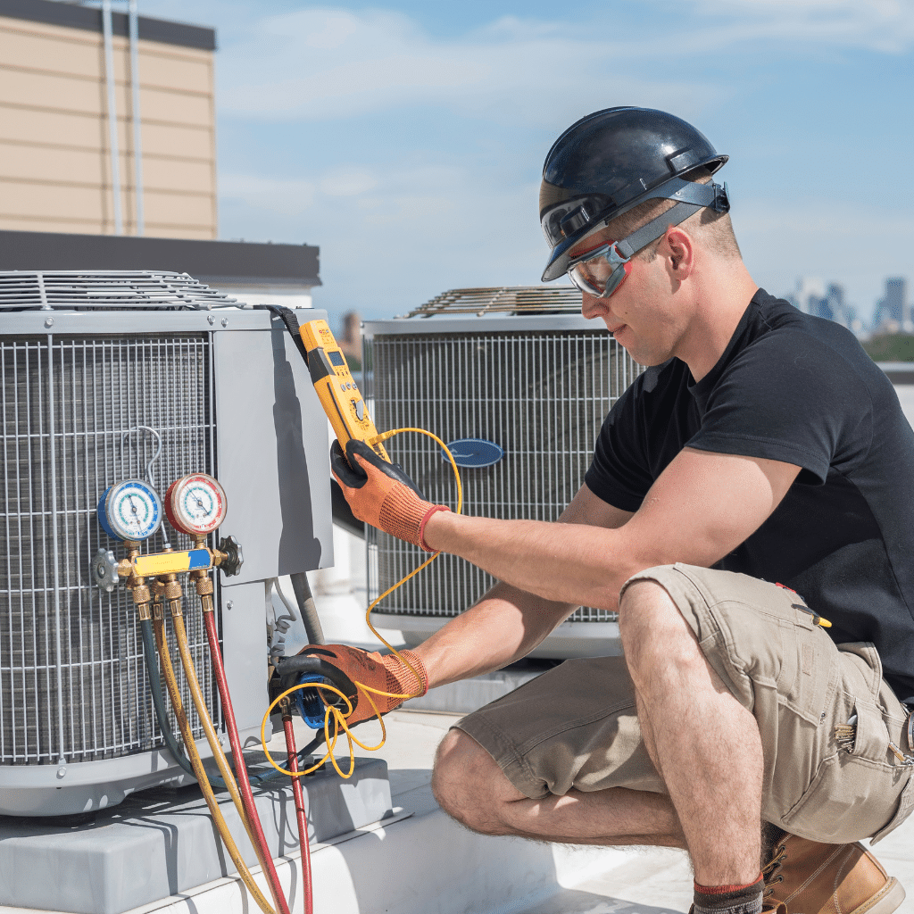 Commercial HVAC technician working on air conditioning unit
